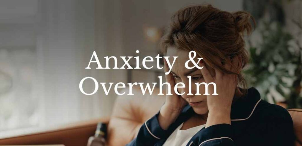 Woman sitting with hands on her temples, appearing stressed and overwhelmed, representing anxiety and emotional distress