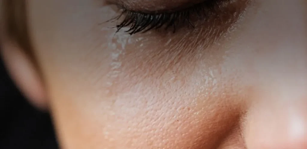 Close-up of a person’s closed eye and face, conveying calm, introspection, and nervous system regulation